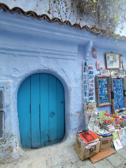       Blue doorway with postcards on display.
  