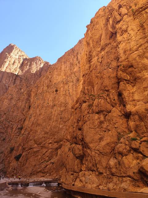       Large rocky cliff face in an arid region.
  