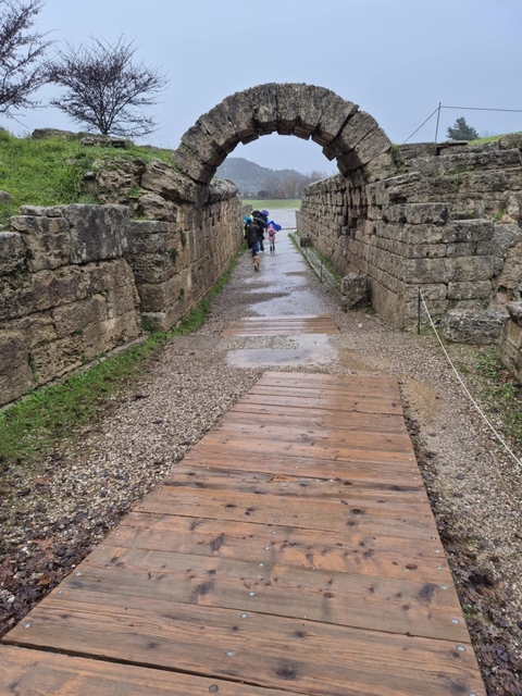 Children walking through an ancient stone gateway.