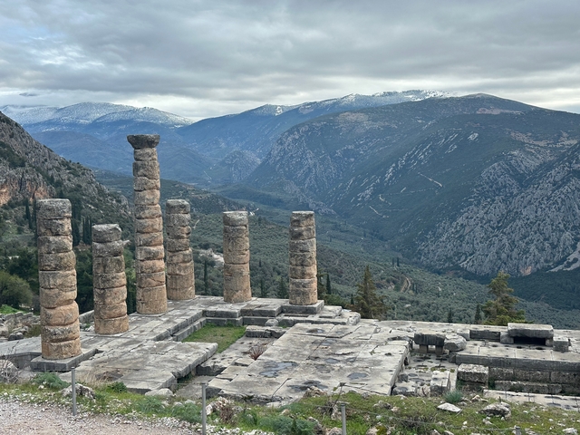 Ancient ruins with rocky mountains in the background.