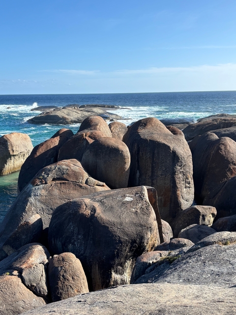 Large coastal rock formations with waves crashing below.