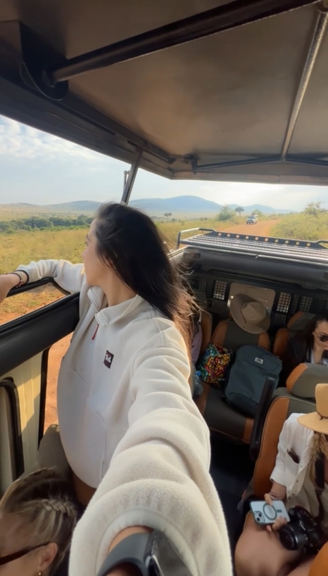       Woman enjoying a safari ride with open vehicle.
  