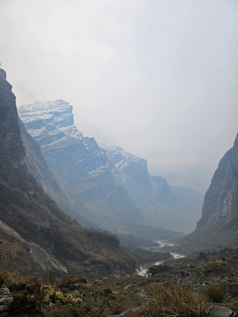 Distant snow-capped mountains under a cloudy sky.