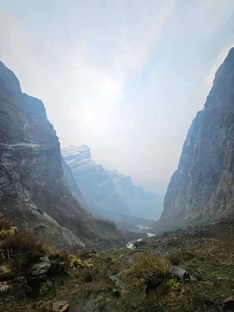 Cloudy mountain landscape with distant peaks.