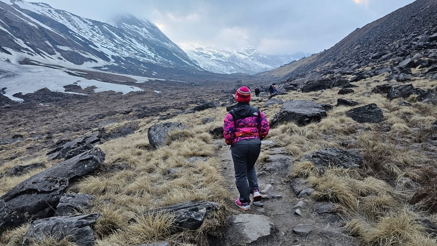 Person walking on a trail in a mountainous region.