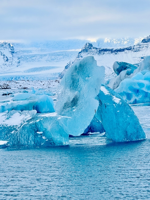 Large ice formations on a frozen surface with a snowy back.