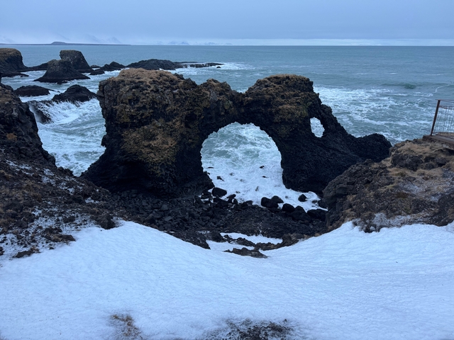 Natural rock arch with view of the sea beyond.