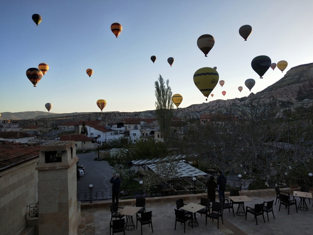       Hot air balloons in the sky over a scenic town landscape.
  