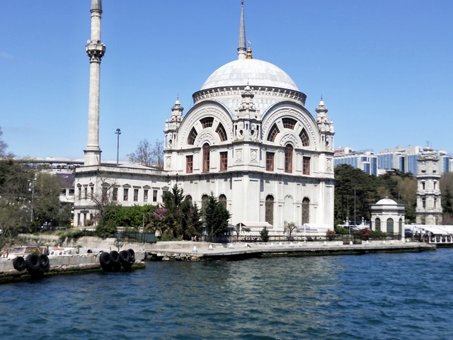       Beautiful ornate white building by the waterside.
  