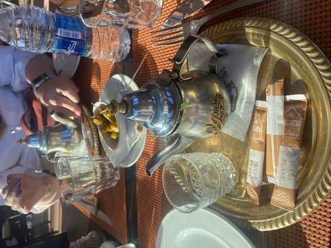       Tea set on a table with people dining.
  