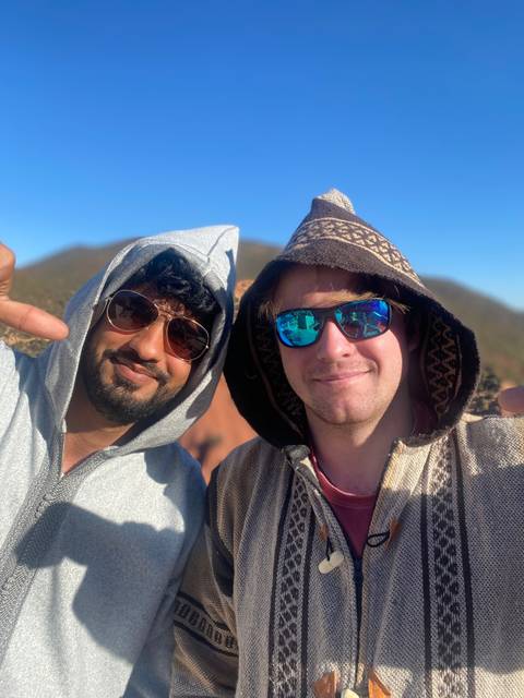       Two men smiling in traditional attire.
  