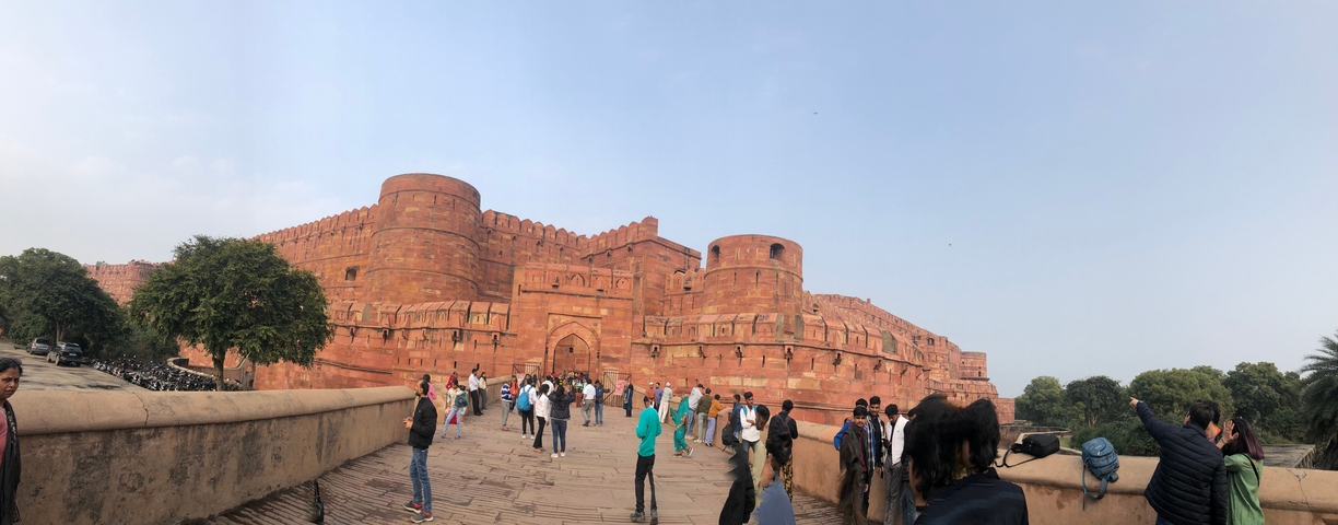 Red fort with many visitors near the entrance.