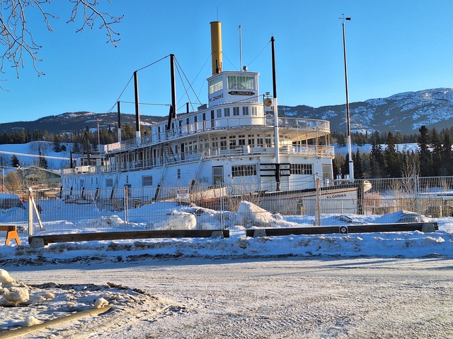 Historic steamship docked in a snowy environment.