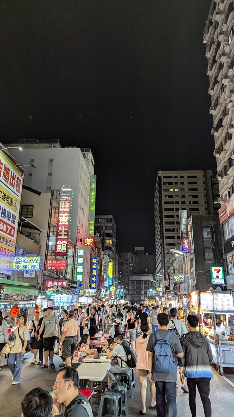       Night view of a street with neon signs in Taipei.
  