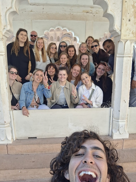 Group of people posing in a historic building's archway.