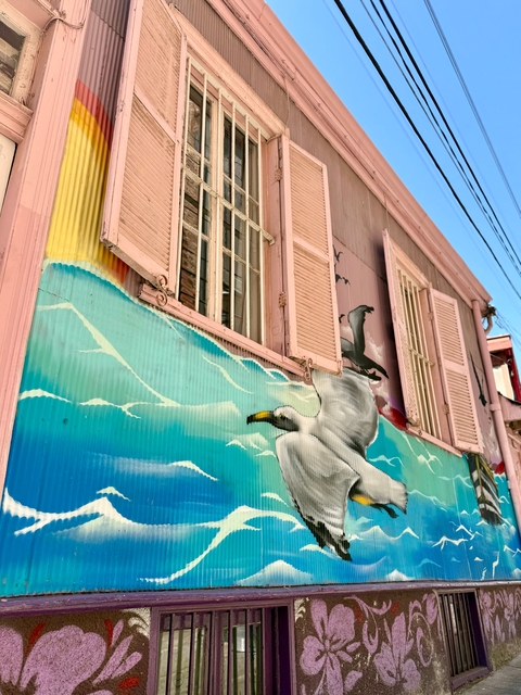Building with vibrant mural under a blue sky.