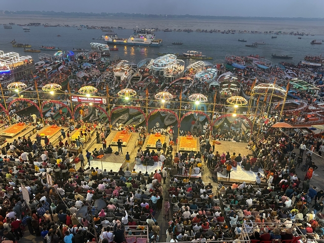 Evening gathering at riverside with boats and decorations.