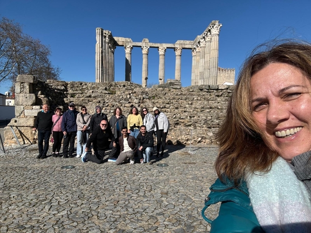 A group posing at ancient Roman ruins.