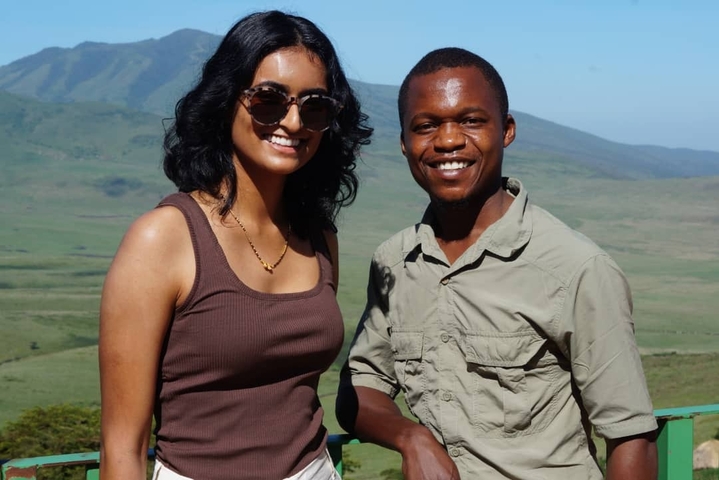       Two people posing with a scenic landscape in the background.
  
