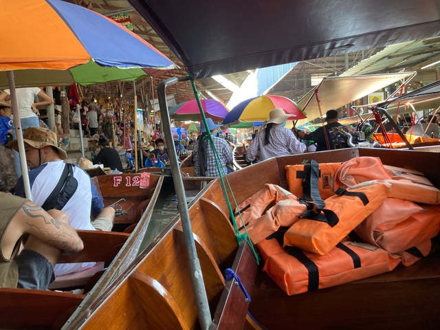 Busy floating market with colorful boats and umbrellas.
