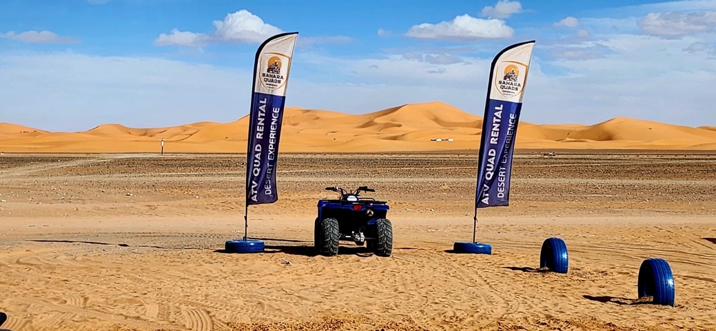 Quad bike rental spot with sand dunes in the background.