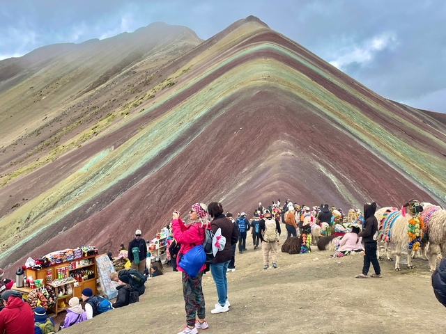       Tourists and alpacas at the colorful Rainbow Mountain.
  