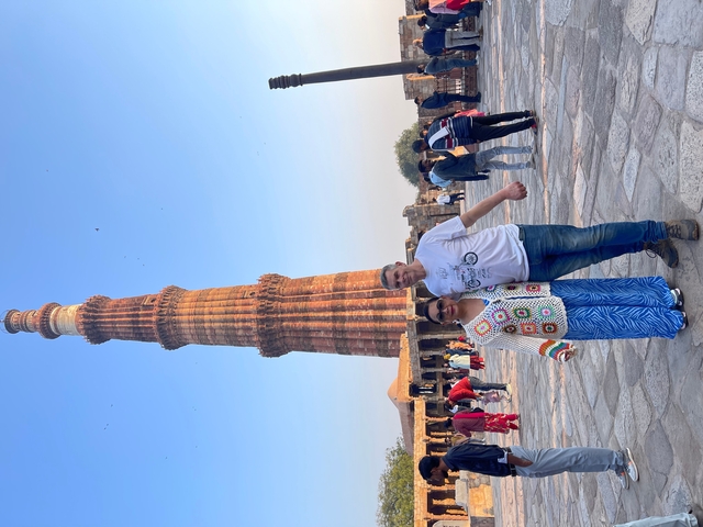       Couple posing in front of the iconic Qutub Minar.
  