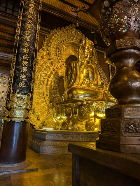       A golden Buddha statue inside a temple.
  