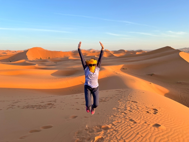       Person jumping in the dunes of a desert.
  