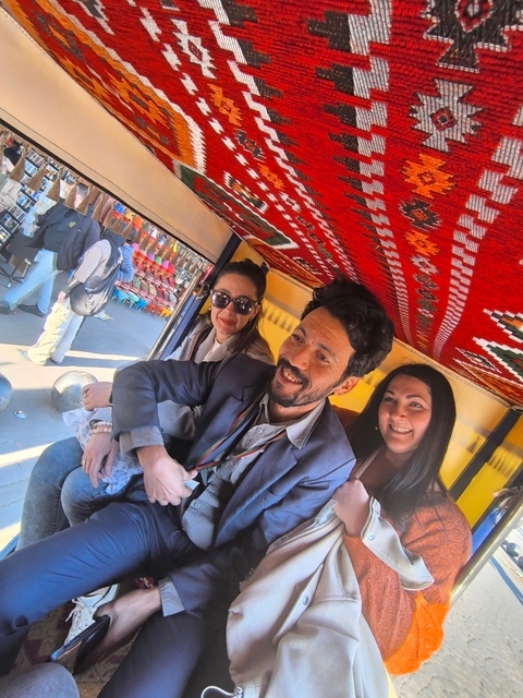 People sitting in a decorated vehicle.