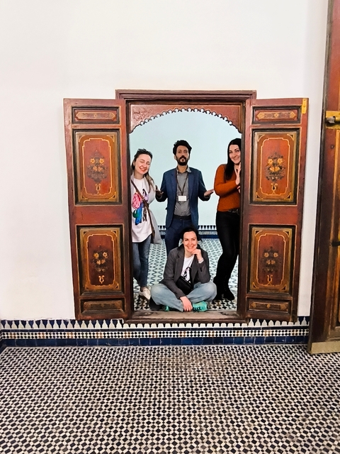Group of people posing in front of ornate wooden doors.