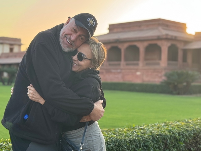       Couple embracing in front of a historic structure.
  