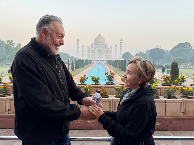       Couple posing in front of the Taj Mahal.
  