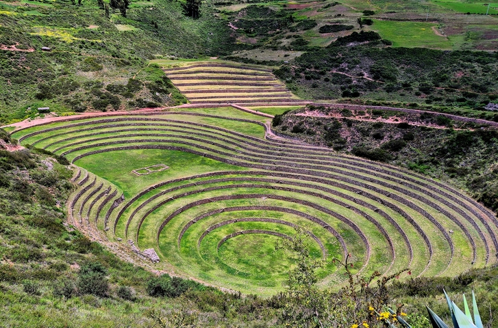       Circular terraced ruins in a green valley.
  