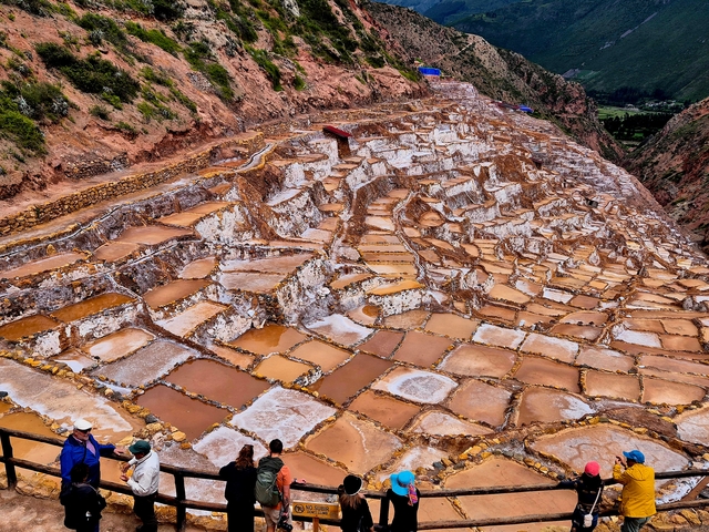 Expansive view of stepped salt pans in a valley.