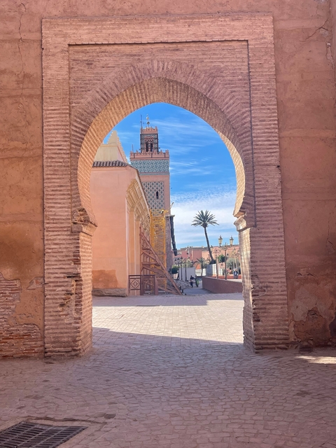View through a decorative archway towards a mosque with scaffolding.