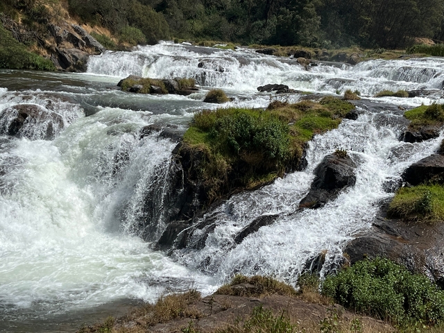 Rushing waters over rocks at a waterfall.