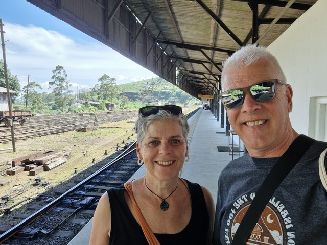 Couple posing at a train station.