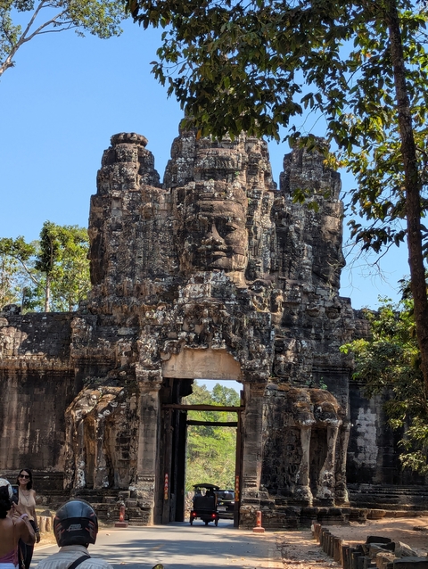       Ancient stone entrance with carved faces.
  