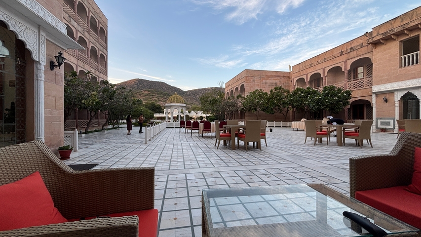       Courtyard of a luxurious hotel with scenic mountains.
  