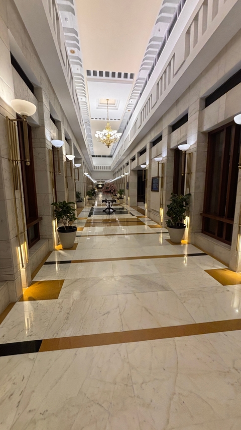       Luxurious hallway with polished floors and plant decorations.
  