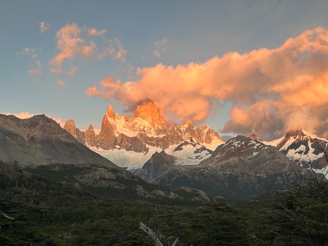       Sunlit mountain peaks with clouds at sunset.
  