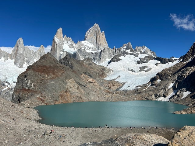      Majestic mountain peaks with a deep blue lake.
  