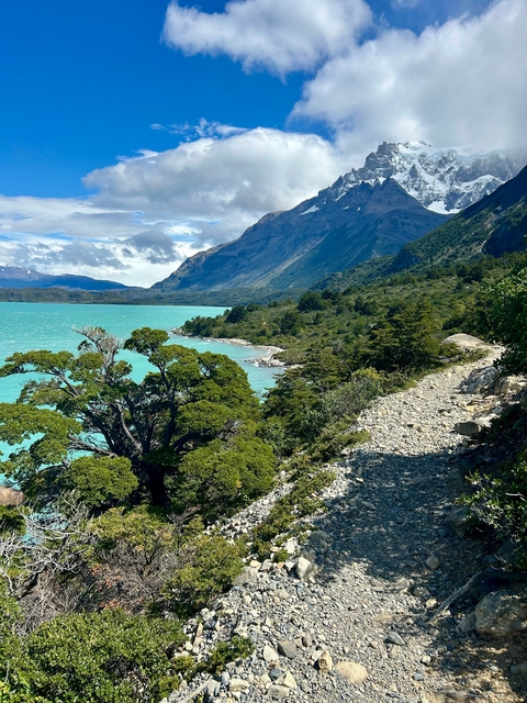       Coastal landscape with a vivid turquoise lake and mountains.
  