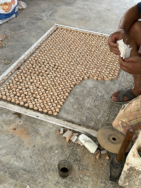       Close-up of tessellated stone tiles being laid out.
  