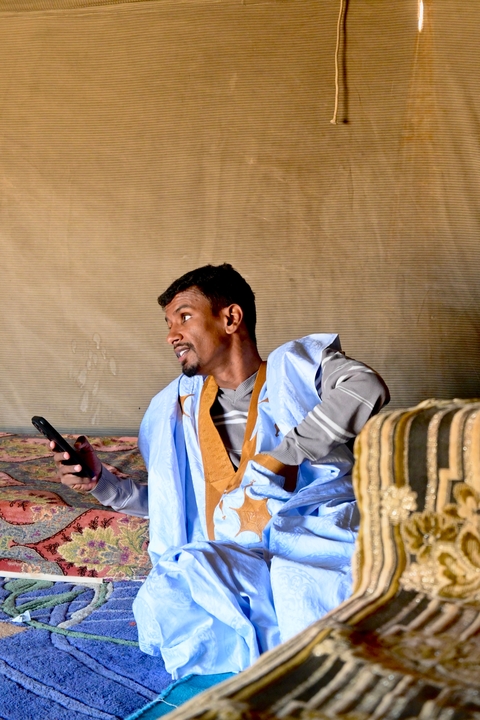 Man in traditional attire using a smartphone