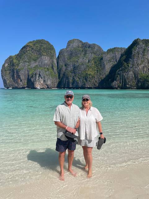 Couple posing on a beach with cliffs