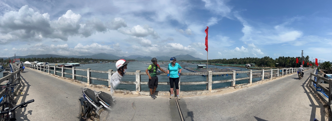 People standing on a bridge with a flag