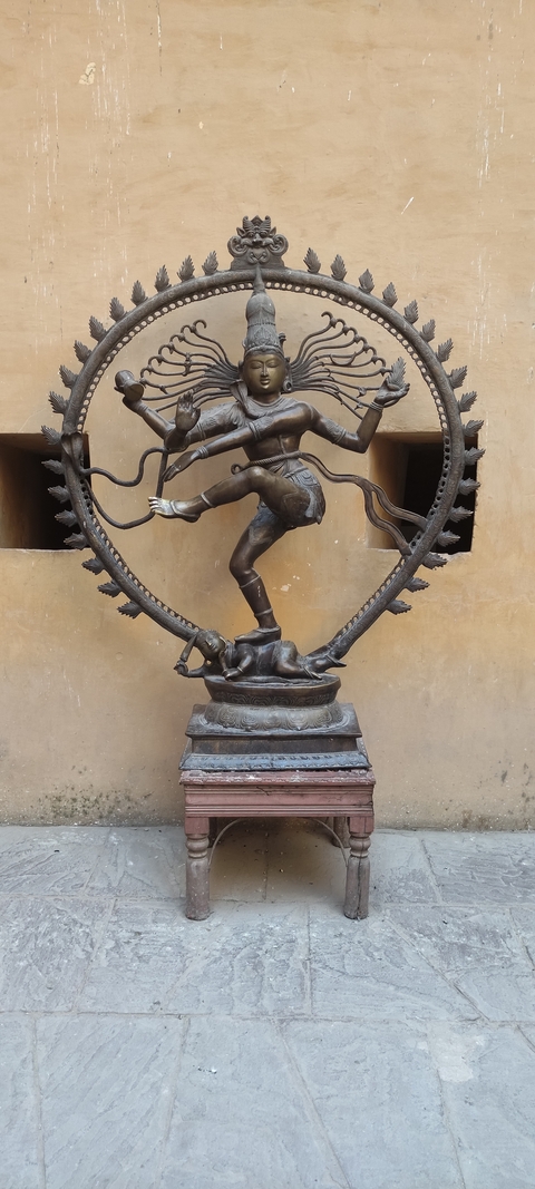 Statue of a dancing figure with surrounding ornate details.