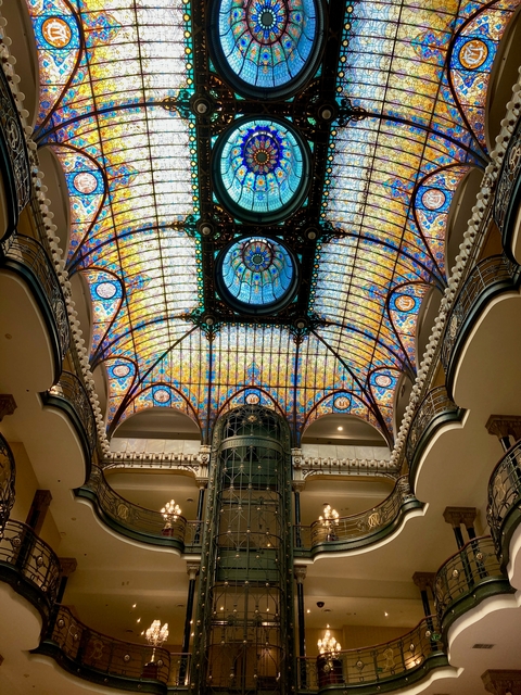       Intricate stained glass ceiling in a grand building.
  